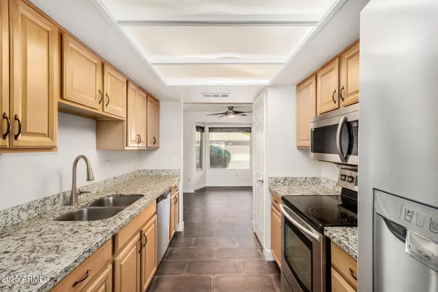 a kitchen with stainless steel appliances granite countertop a sink stove and refrigerator