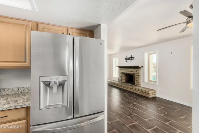 a kitchen with granite countertop a refrigerator and a stove top oven
