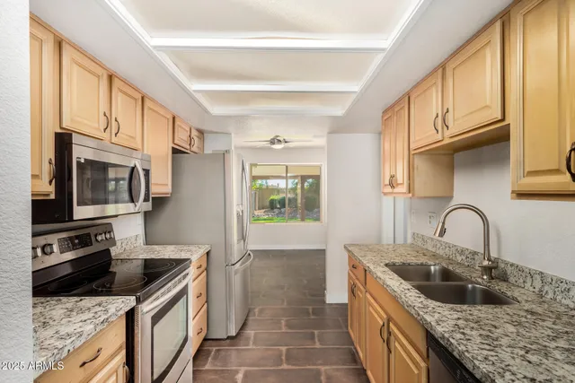 a kitchen with granite countertop a sink and a stove top oven