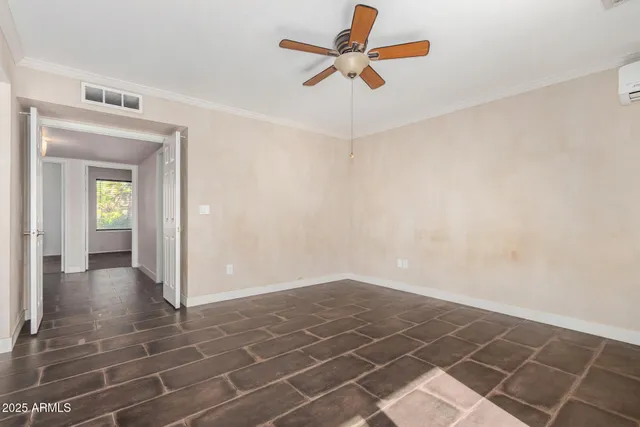 an empty room with closet and fan