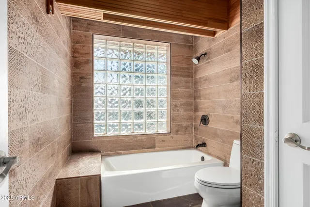 a bathroom with a bathtub a shower and a toilet