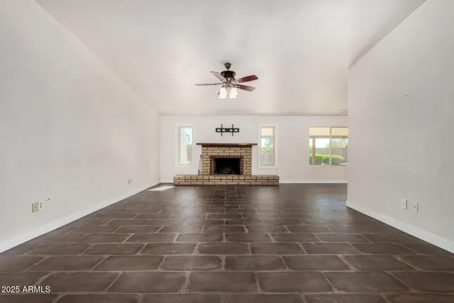 an empty room with windows and fireplace