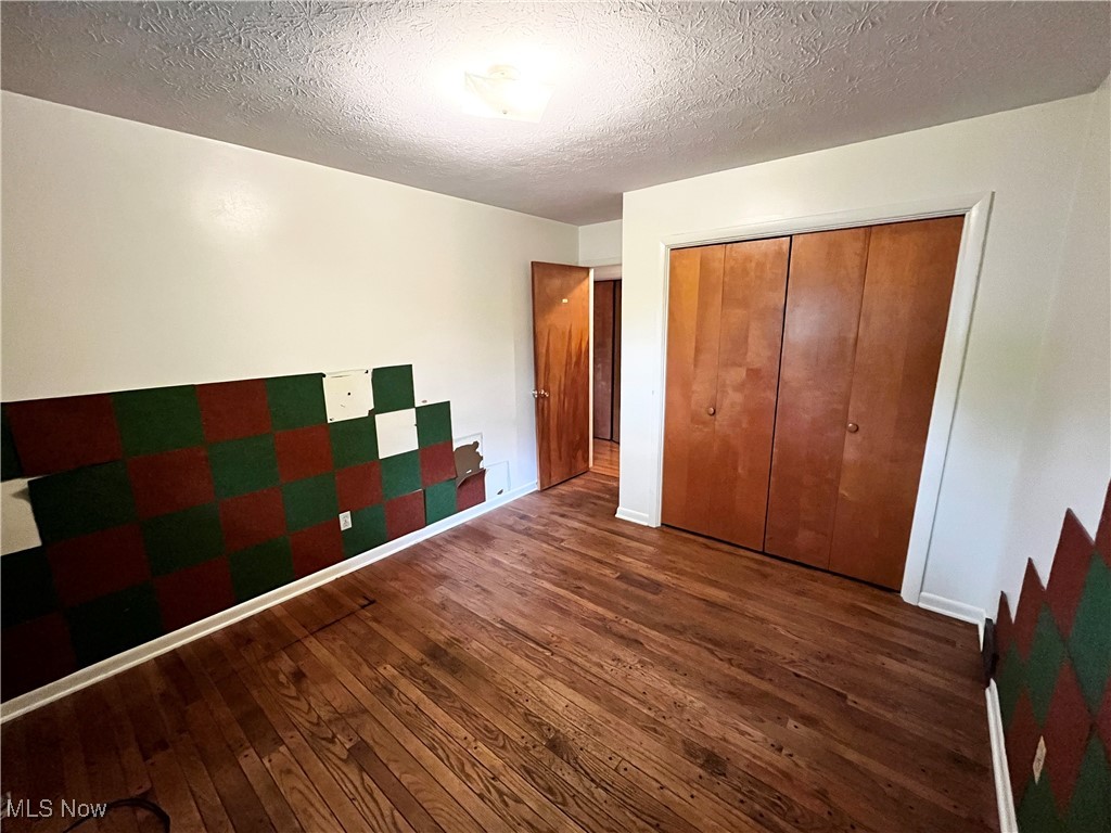 2300 River Road Willoughby, OH 44094 - Photo 16 of 28 Unfurnished bedroom with hardwood / wood-style floors, a textured ceiling, and a closet