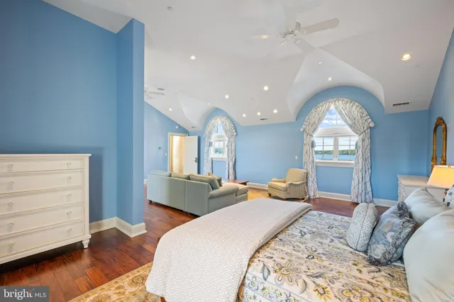 a kitchen with stainless steel appliances granite countertop a refrigerator a stove top oven and a dining table with wooden floor