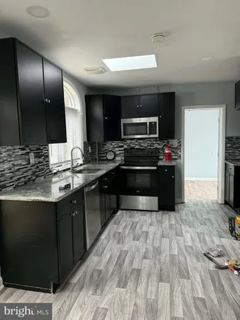 a kitchen with stainless steel appliances granite countertop a sink and a stove