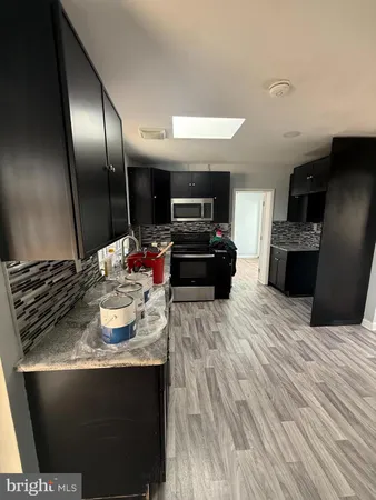 a kitchen with kitchen island granite countertop stainless steel appliances and view of living room