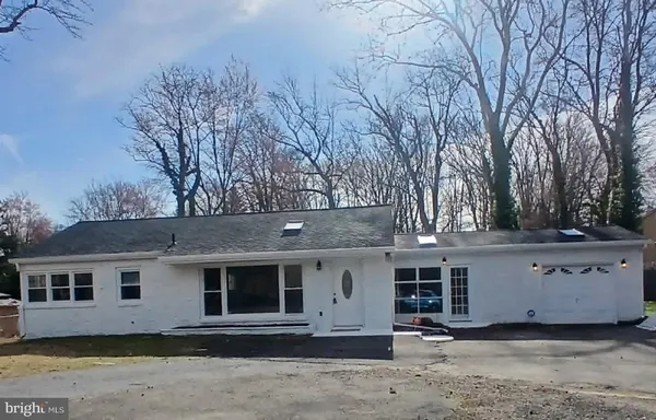 a front view of a house with a tree