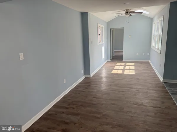 a view of a hallway with wooden floor and a chandelier
