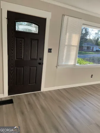 an empty room with wooden floor and a window