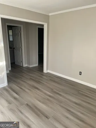 a view of an empty room with wooden floor