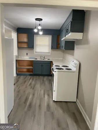 a kitchen with granite countertop a sink and a stove top oven