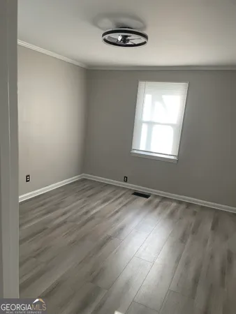 wooden floor in an empty room with a window