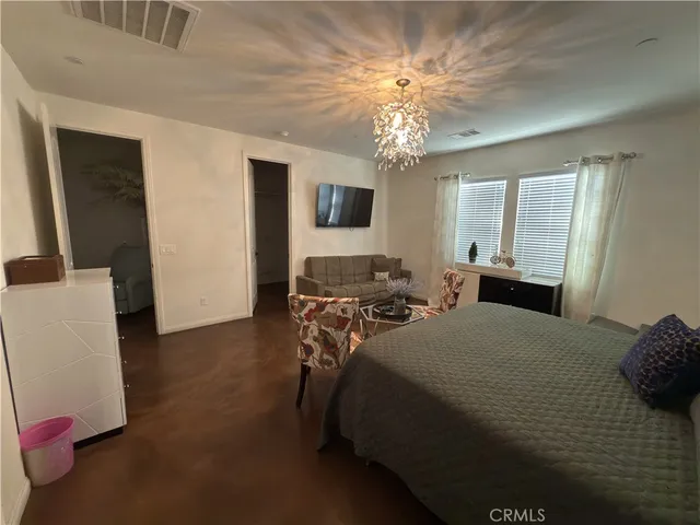 a bedroom with a bed and a chandelier