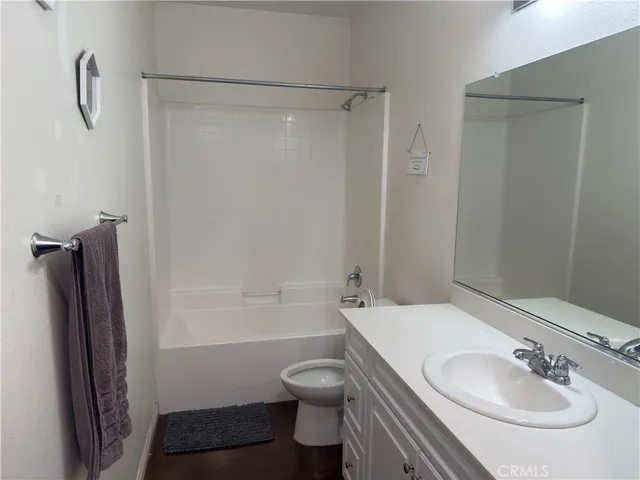 a bathroom with a granite countertop sink toilet a shower and a mirror