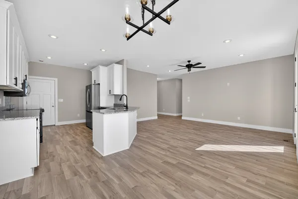 a kitchen with granite countertop white cabinets and a sink
