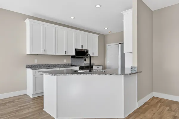 a view of a kitchen with wooden floor and a window