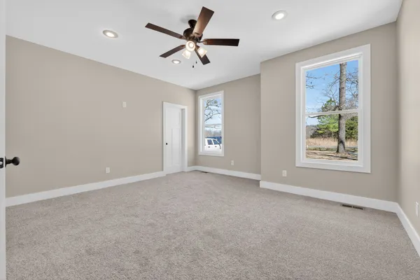 an empty room with fan and entrance