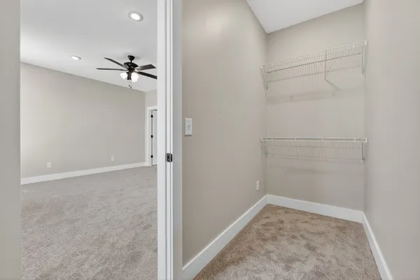 an empty room with ceiling fan and window