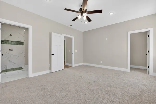 an empty room with a window and a ceiling fan