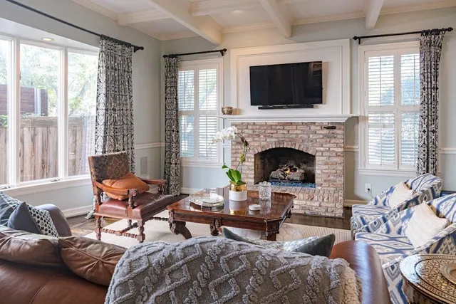 a living room with furniture a fireplace and a flat screen tv