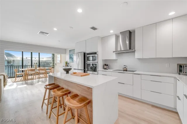 a kitchen with stainless steel appliances kitchen island granite countertop a sink and cabinets
