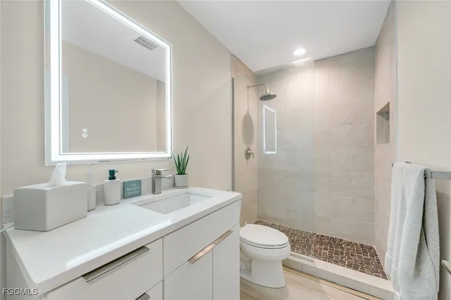 a bathroom with a sink a toilet a shower and a mirror