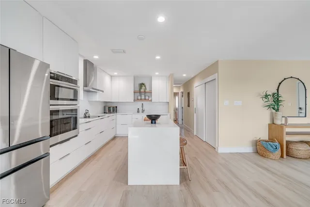 a large white kitchen with stainless steel appliances
