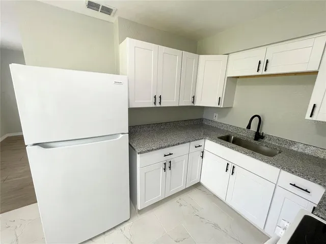a white refrigerator freezer sitting inside of a kitchen