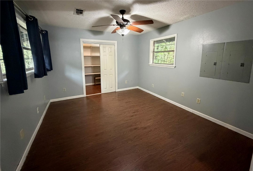 5108 Ridge Road Alma, AR 72921 - Photo 19 of 33 Spacious room featuring wood-finish flooring, two windows, and a ceiling fan with light fixture