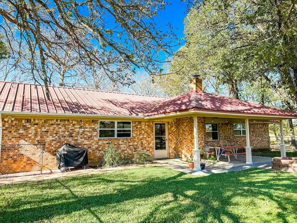 a view of a house with backyard porch and sitting area