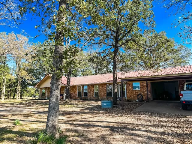 a front view of a house with a tree