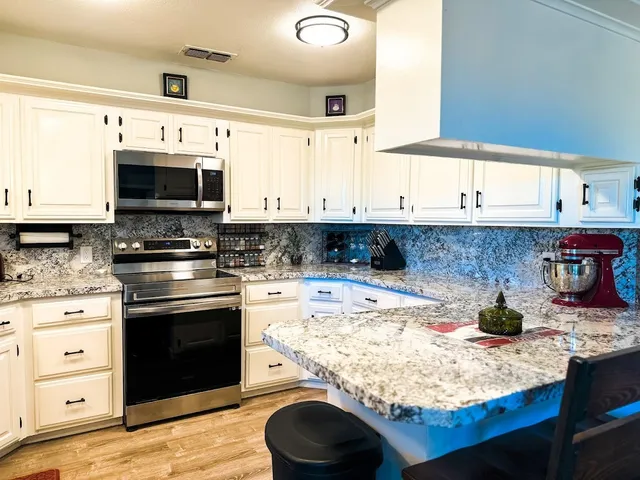 a kitchen with stainless steel appliances granite countertop a stove and a microwave