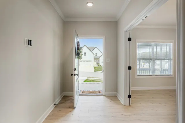 a view of a livingroom with a fireplace a ceiling fan and windows