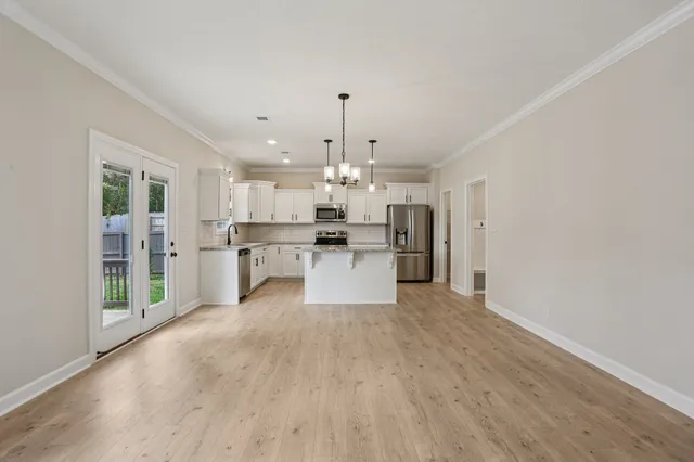 a kitchen with stainless steel appliances granite countertop a refrigerator a stove a sink a microwave and white cabinets