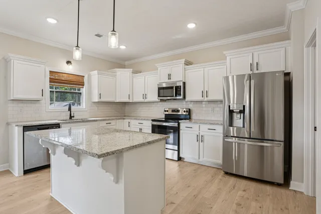 a kitchen with stainless steel appliances granite countertop a sink and stove top oven