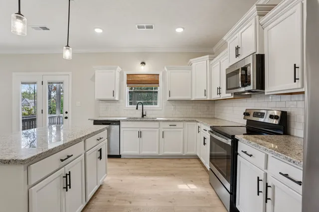 a kitchen with white cabinets sink and stainless steel appliances