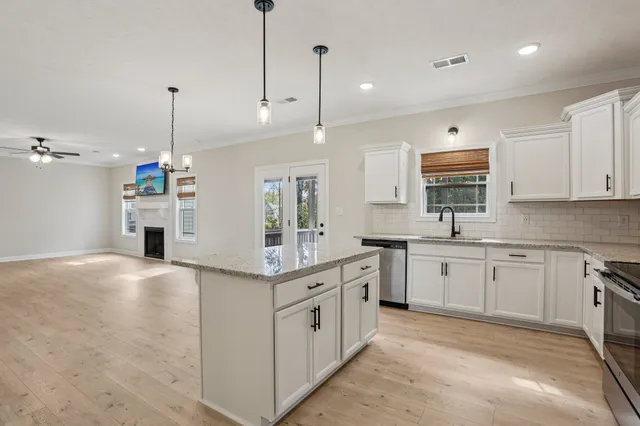 a kitchen with stainless steel appliances granite countertop a refrigerator and a stove