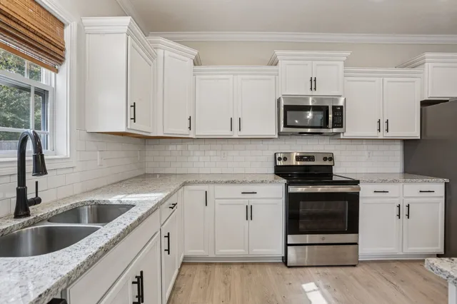 a view of a kitchen with wooden floor and a window