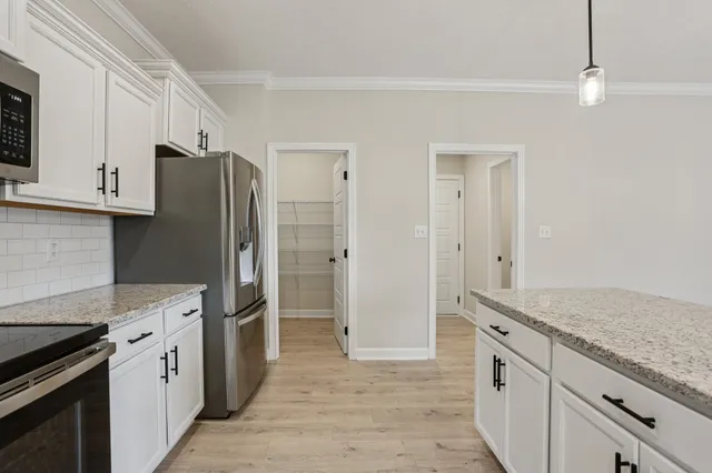 a view of a room with wooden floor and chandelier