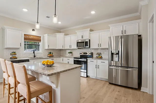 a kitchen with a sink a refrigerator a stove a microwave and cabinets