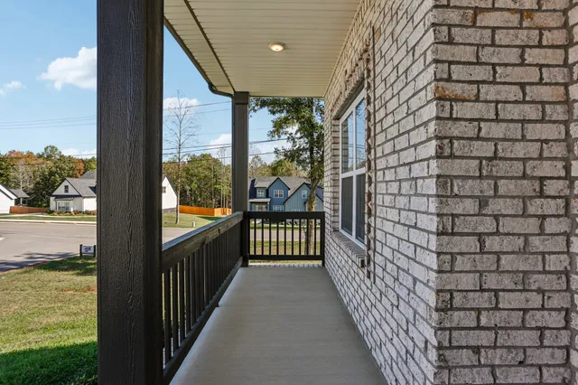 a view of hallway with chandelier and wooden floor