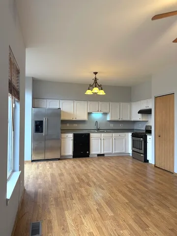 a view of kitchen with kitchen island microwave and cabinets