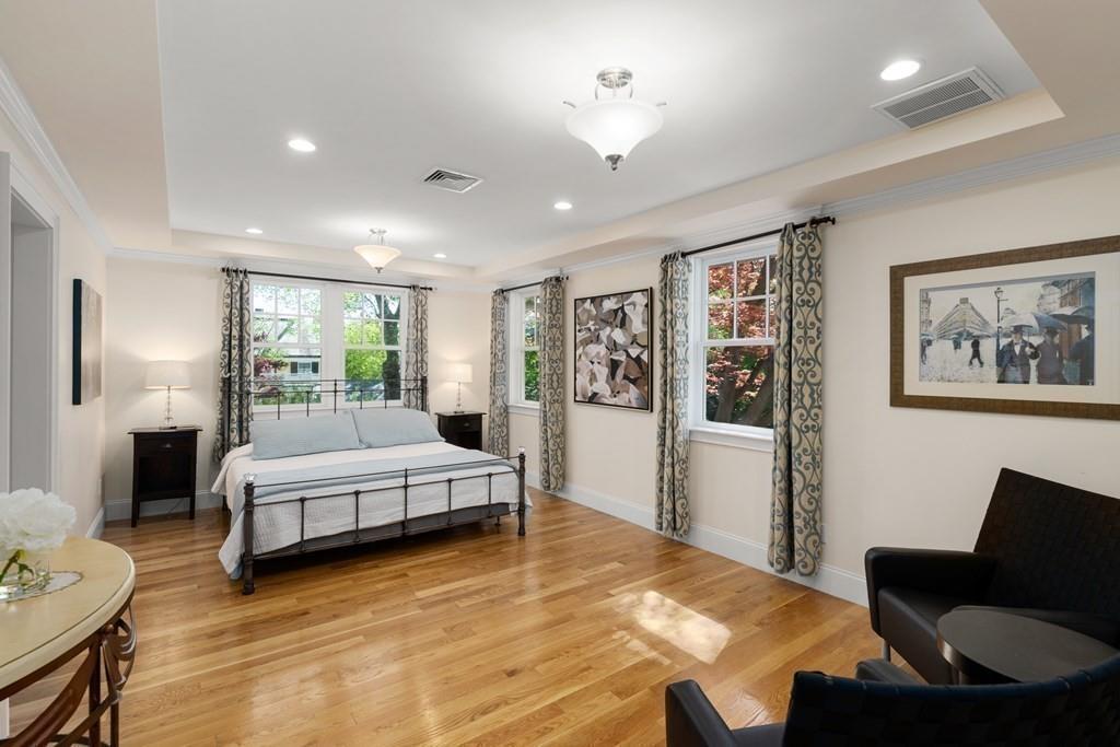 12 Vineyard Road Newton, MA 02459 - Photo 13 of 26 a spacious bedroom with a bed a couch and a bookshelf with wooden floor