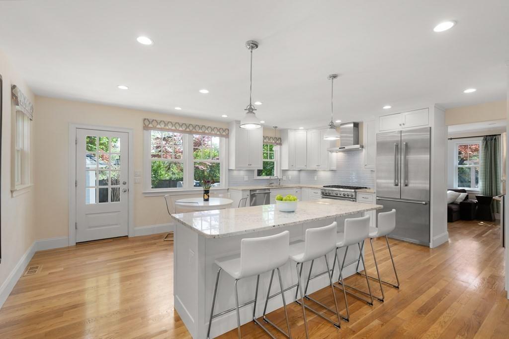 12 Vineyard Road Newton, MA 02459 - Photo 4 of 26 a large kitchen with kitchen island a large counter top space a sink stainless steel appliances and windows
