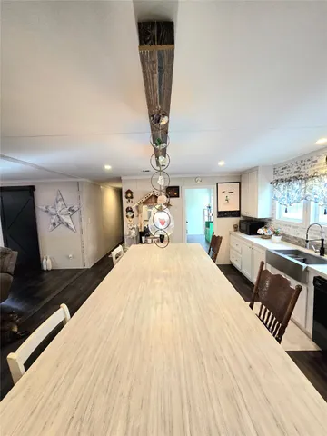 a living room with furniture kitchen view and a large window