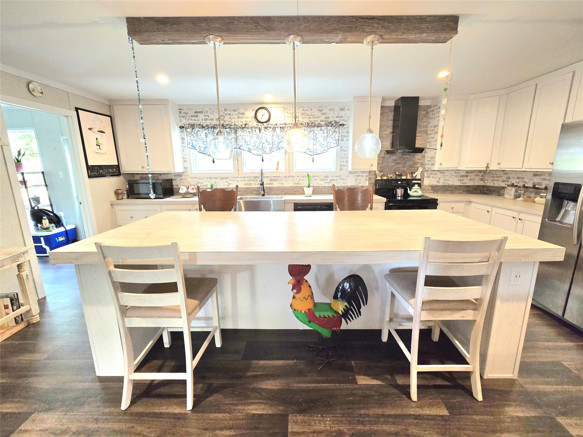 223 County Road 2167B Cleveland, TX 77327 - Photo 10 of 50 a kitchen with kitchen island granite countertop a dining table chairs and white cabinets