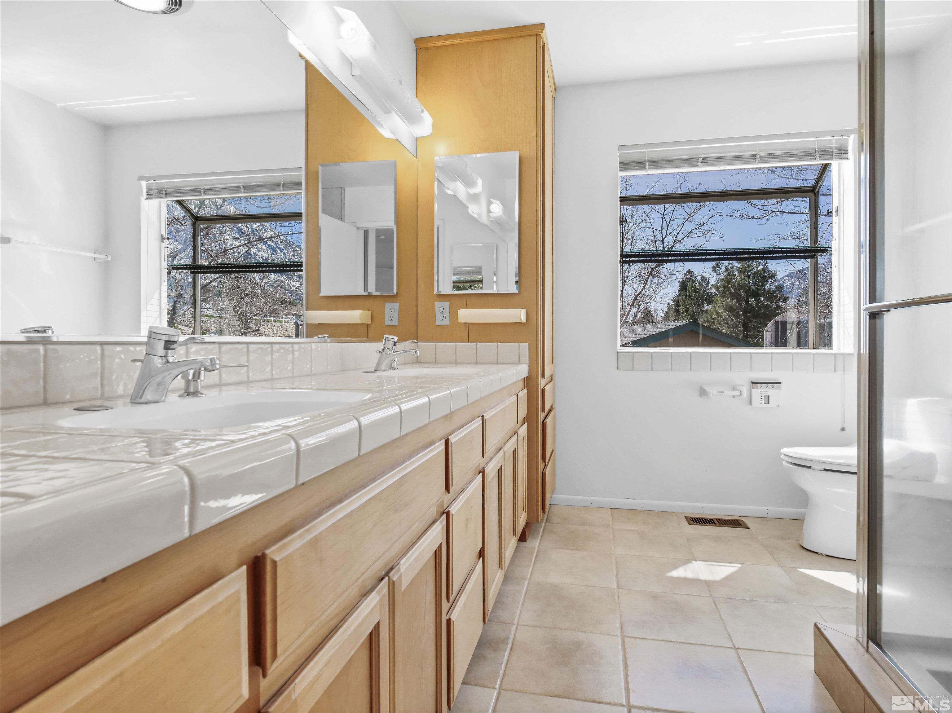 875 Bollen Circle Gardnerville, NV 89460 - Photo 14 of 26 a bathroom with a granite countertop sink mirror vanity and toilet