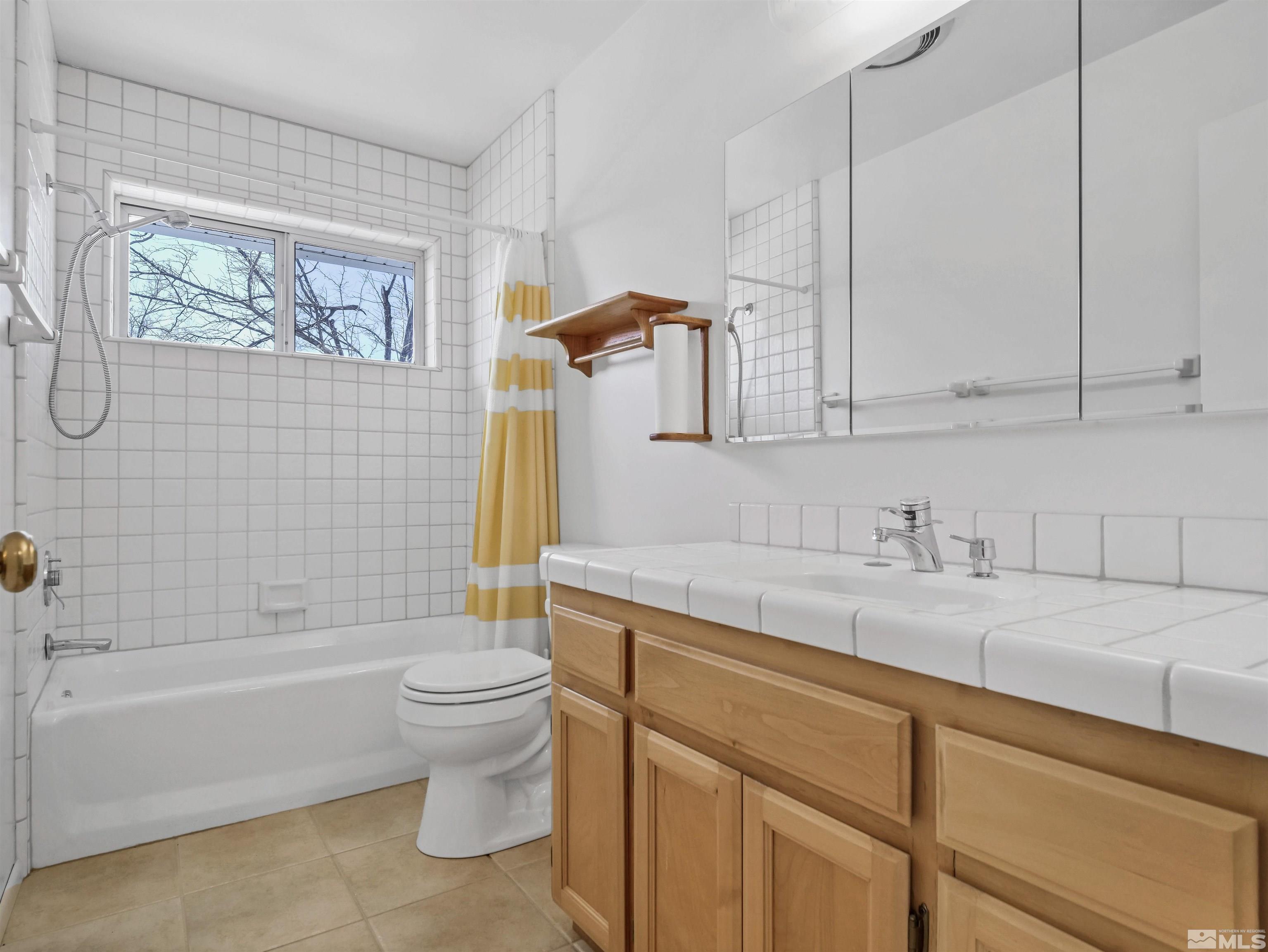 875 Bollen Circle Gardnerville, NV 89460 - Photo 10 of 26 a bathroom with a granite countertop sink a toilet and bathtub