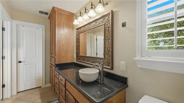 a bathroom with a granite countertop sink a mirror and a shower