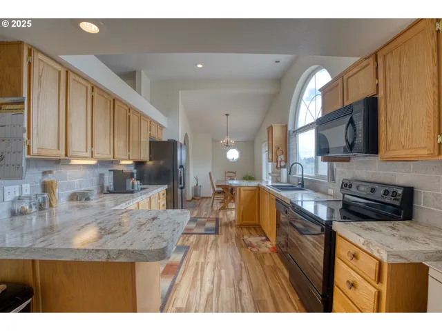 a kitchen with stainless steel appliances granite countertop wooden cabinets a stove top oven a sink and dishwasher